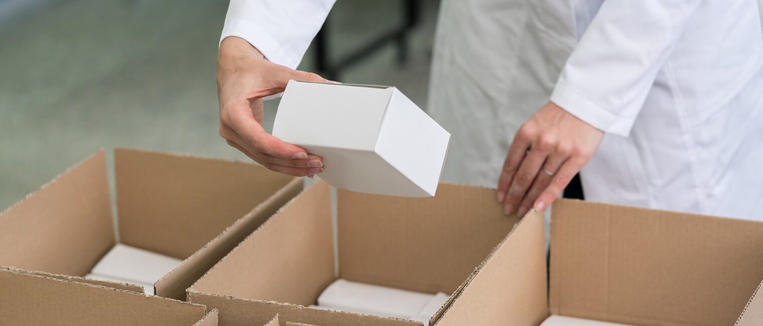 Arbeiter verpackt Ware in Kartons. 