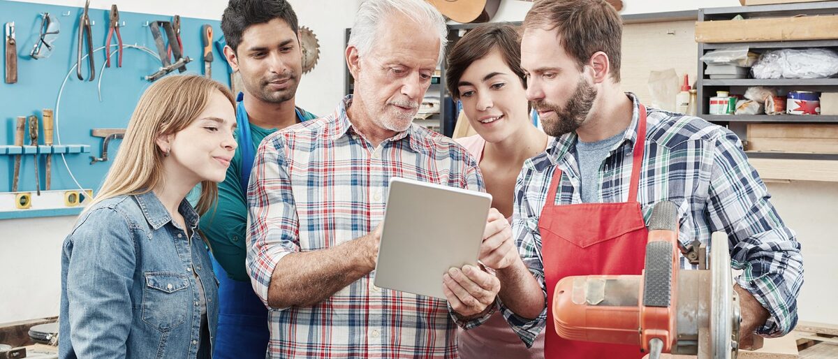 Handwerker zeigt Personen, die um ihn herumstehen, etwas auf einem Tablet. Handwerker mit Laptop machen einen Computer Workshop zur Fortbildung Schlagwort(e): Arbeit, Arbeiter, Ausbildung, Azubi, Beruf, Betrieb, Computer, Fortbildung, Gitarre, Gitarrenbauer, Gruppe, Handwerk, Handwerker, Holzarbeit, Holzarbeiter, Holzbau, Holzverarbeitung, Integration, Internet, Kleinbetrieb, Kollegen, Kommunikation, Lehre, Lehrling, Leute, Mann, Meister, PC, Recherche, Schreiner, Schulung, Senior, Tablet, Team, Tischler, Weiterbildung, Werkstatt, alt, digital, mobil, modern, multikulturell, online, traditionell, zusammen