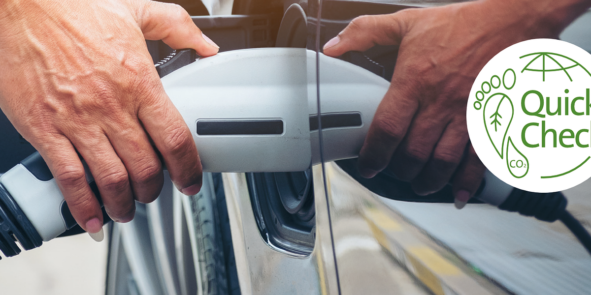 Nahaufnahme Ladung eines Elektroautos. Rechts ein runder Banner mit einem grünem Fuß und den Worten Quick-Check.