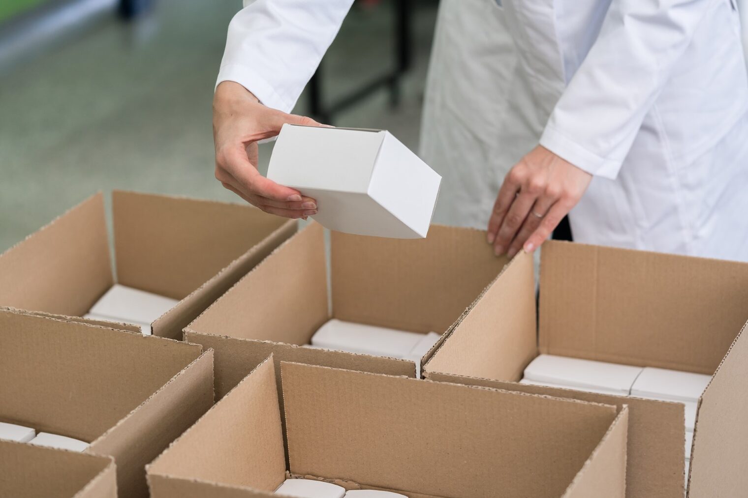 Arbeiter verpackt Ware in Kartons.
