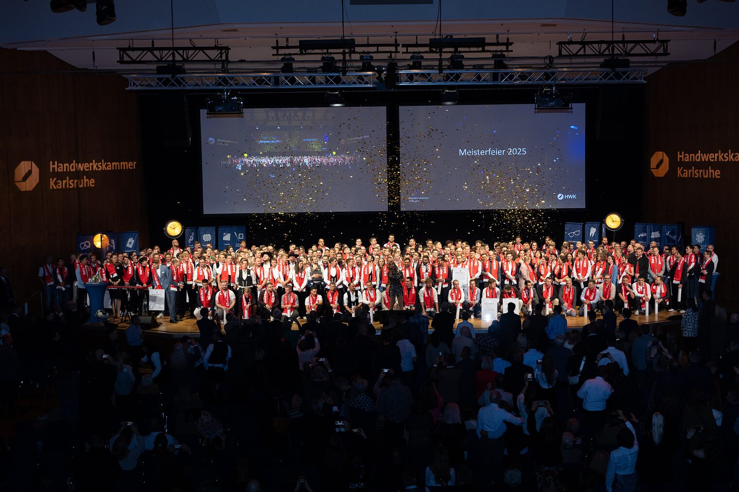Zahlreiche junge Leute auf einer Bühne im Glitterregen