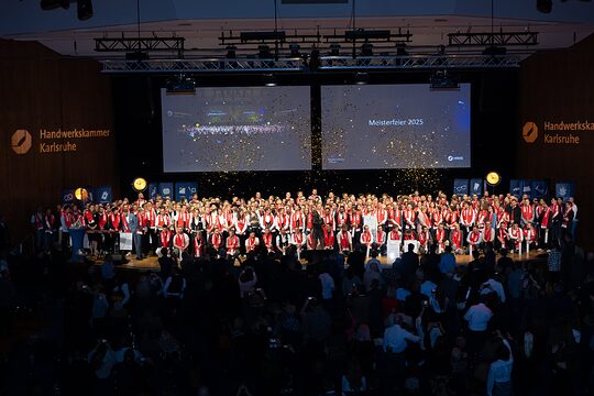 Zahlreiche junge Leute auf einer Bühne im Glitterregen
