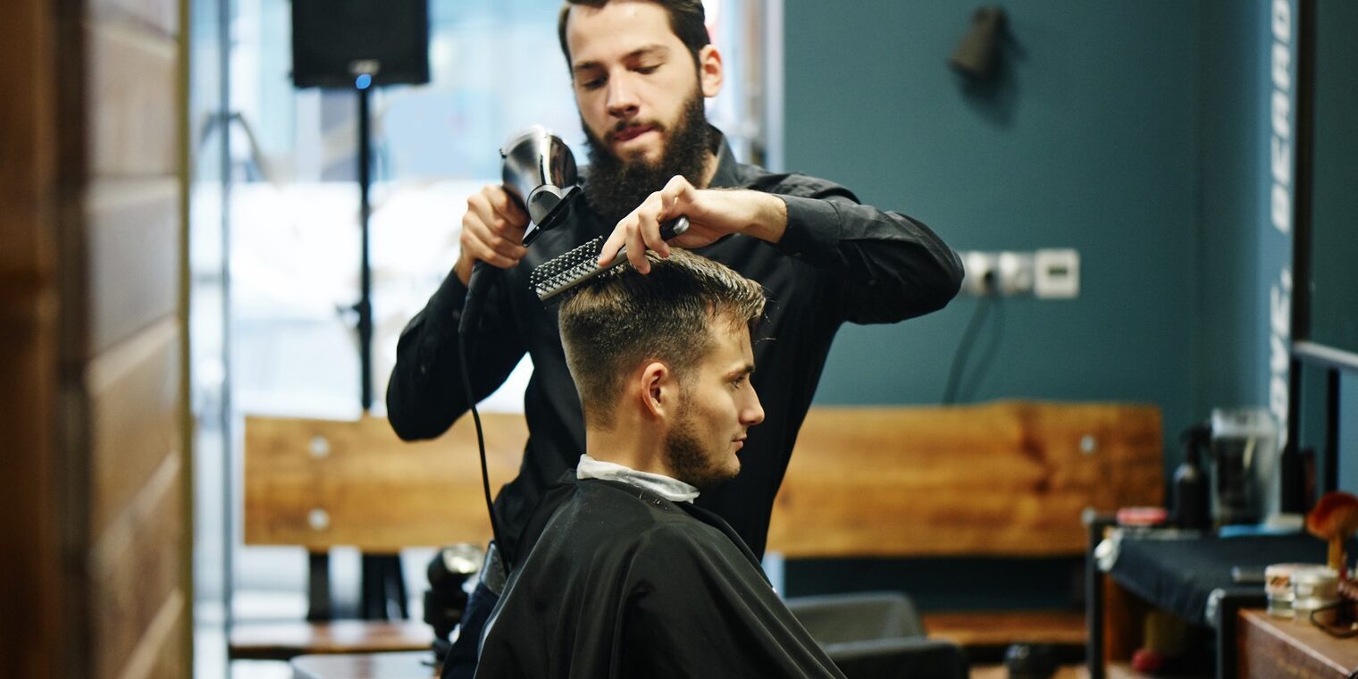 Friseur schneidet einem Kunden die Haare.