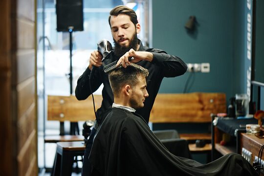 Friseur schneidet einem Kunden die Haare.