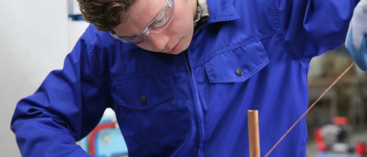 student in plumbing professional training, working on copper Schlagwort(e): metallurgy, welder, solderer, plumber, plumbing, copper, professional, craftsman, craftsmanship, young, man, apprentice, training, trainee, apprenticeship, overall, blue, protection, protective, glasses, melting, worker, working, workshop, heating, student, metallurgy, welder, solderer, plumber, plumbing, copper, professional, craftsman, craftsmanship, young, man, apprentice, training, trainee, apprenticeship, overall, blue, protection, protective, glasses, melting, worker, working, workshop, heating, student, ausbildung