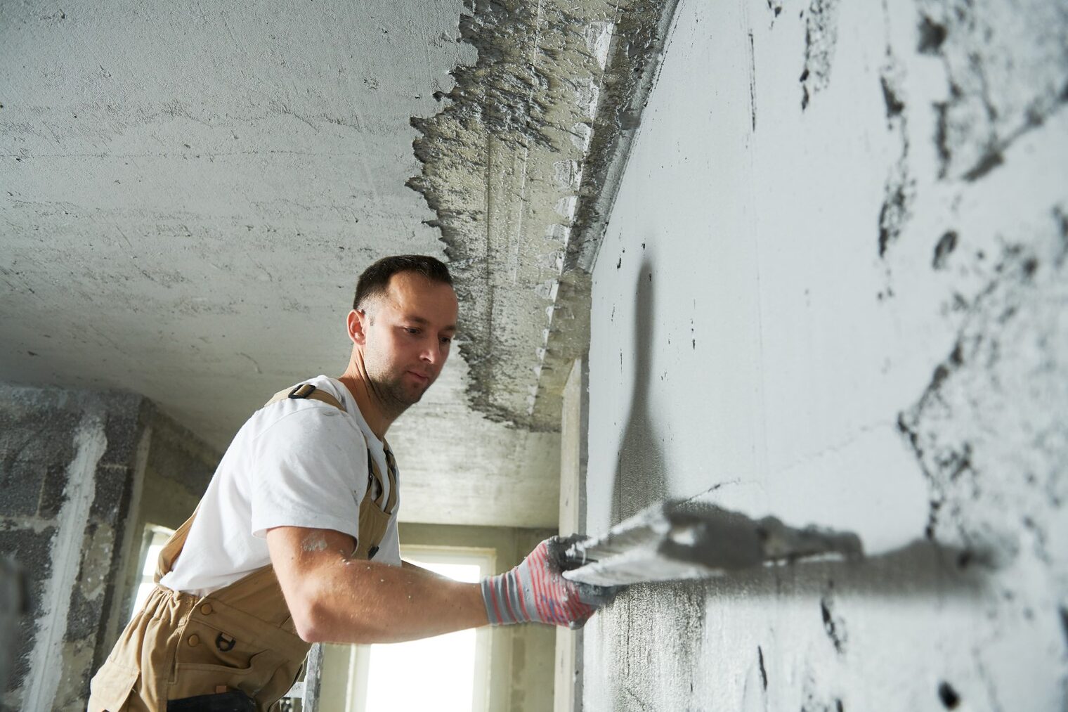 Plasterer using screeder spraying thin-layer putty plaster mortar finishing on brick wall Schlagwort(e): plastering, plaster, plasterer, wall, walling, renovation, renewal, finishing, coating, mortar, screeder, worker, man, building, builder, construction, contractor, technology, industry, interior, troweling, putting, indoors, person, room, apartment, screeding, structure, working, workman, plastering, plaster, plasterer, wall, walling, renovation, renewal, finishing, coating, mortar, screeder, worker, man, building, builder, construction, contractor, technology, industry, interior, troweling, putting, indoors, person, room, apartment, screeding, structure, working, workman, Titelbild, Konjunktur