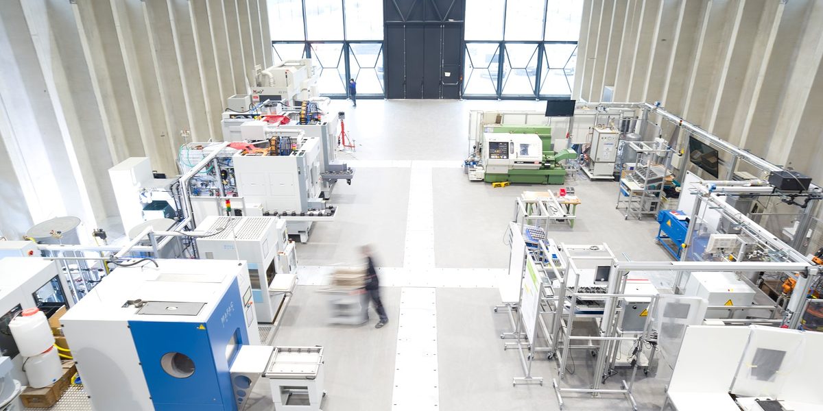 An der ETA-Fabrik der TU Darmstadt auf dem Campus Lichtwiese wird unter Realbedingungen und im Originalmaßstab erforscht, wie sich durch intelligente Vernetzung aller Gebäude- und Produktionskomponenten Energie in der Industrie noch effizienter nutzen lässt. An dem interdisziplinären Forschungsprojekt, das vom Institut für Produktionsmanagement, Technologie und Werkzeugmaschinen (PTW) geleitet wird, sind Wissenschaftler aus den Bereichen Maschinenbau, Bauingenieurwesen und Architektur sowie Partnerunternehmen aus der Industrie beteiligt. Das Gebäude wurde im März 2016 eröffnet. Schlagwort(e): ETA-Fabrik, Forschung, Gebäude, horizontal, Innenaufnahme, Institut für Produktionsmanagement / Technologie und Werkzeugma, Maschinenbau, Versuchshalle